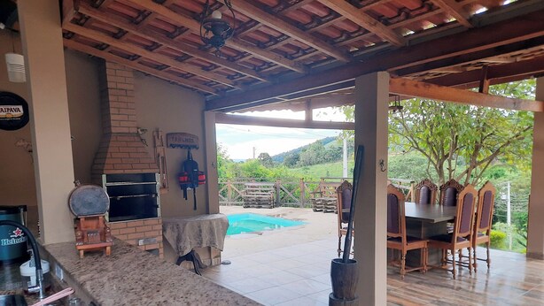 A patio area with a grill, outdoor seating, and a view of the landscape.