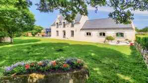 A large house with a well-maintained lawn and flower beds.