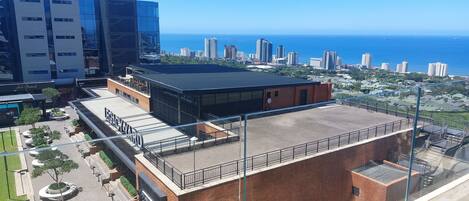 A building with a flat roof, a brick facade, and a large open space.