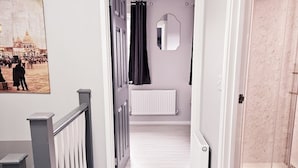 A hallway with a radiator, a shower area, and a door leading to a room. - Modern 2BR 5minutes walk Anfeild| Free parking+ Ev (Liverpool)