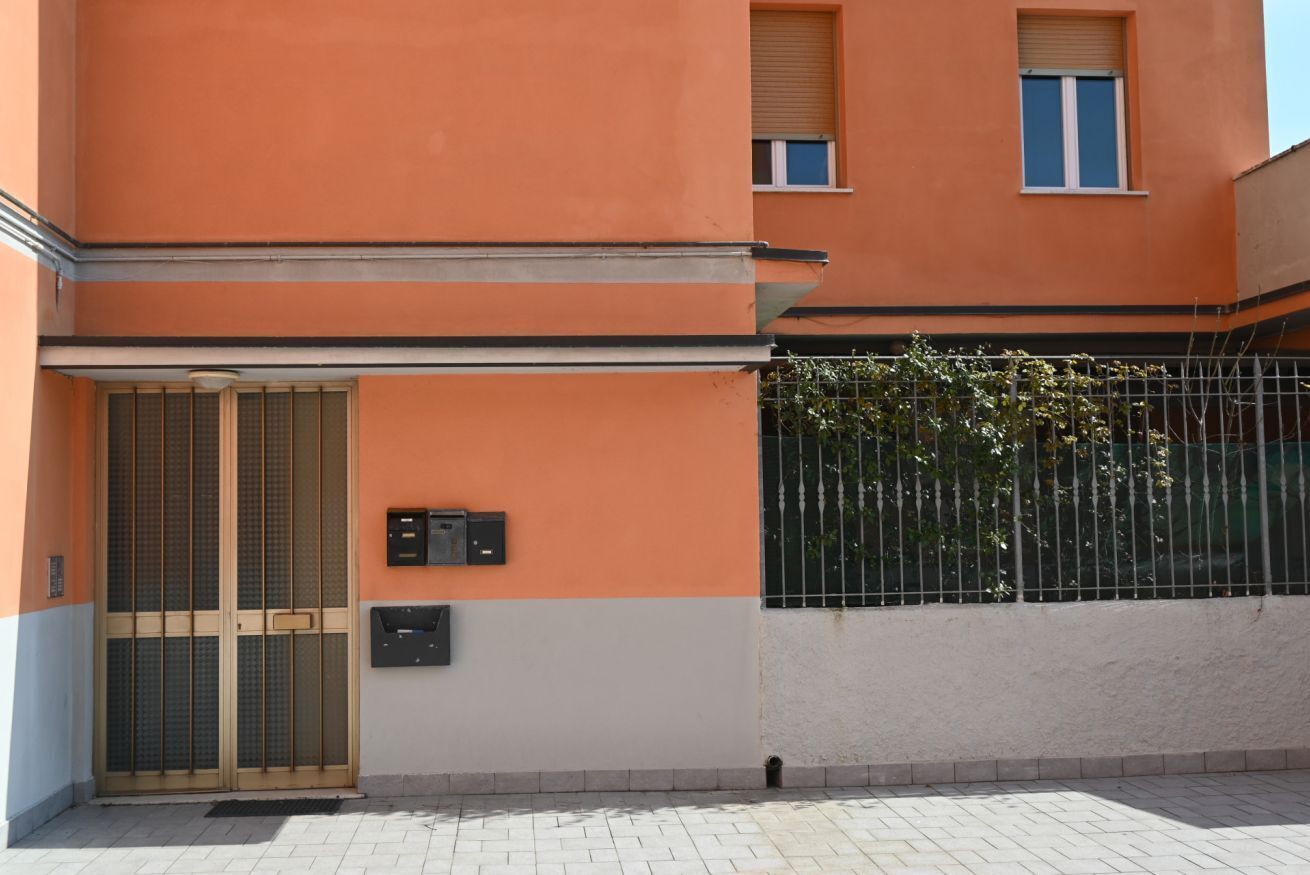 Un bâtiment doté d’un grand portail en métal, d’une petite fenêtre et d’une boîte aux lettres fixée au mur.