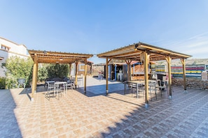 An outdoor patio area with pergolas, tables, and chairs.