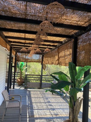 A covered outdoor area with a wooden deck, wicker furniture, and potted plants. - Double mobile, large terrace, sports activities, swimming pool, beach 12 km, (FREJUS)