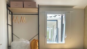 Ein kleines Zimmer mit Etagenbett, einem Fenster mit Ausblick und einer integrierten Ablage.