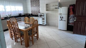 Een moderne keuken met een eethoek, witte betegelde wanden en een plafond met een lineair patroon.