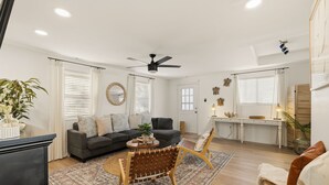 Una sala de estar moderna con un sofá, sillones, una mesa de centro y un comedor.