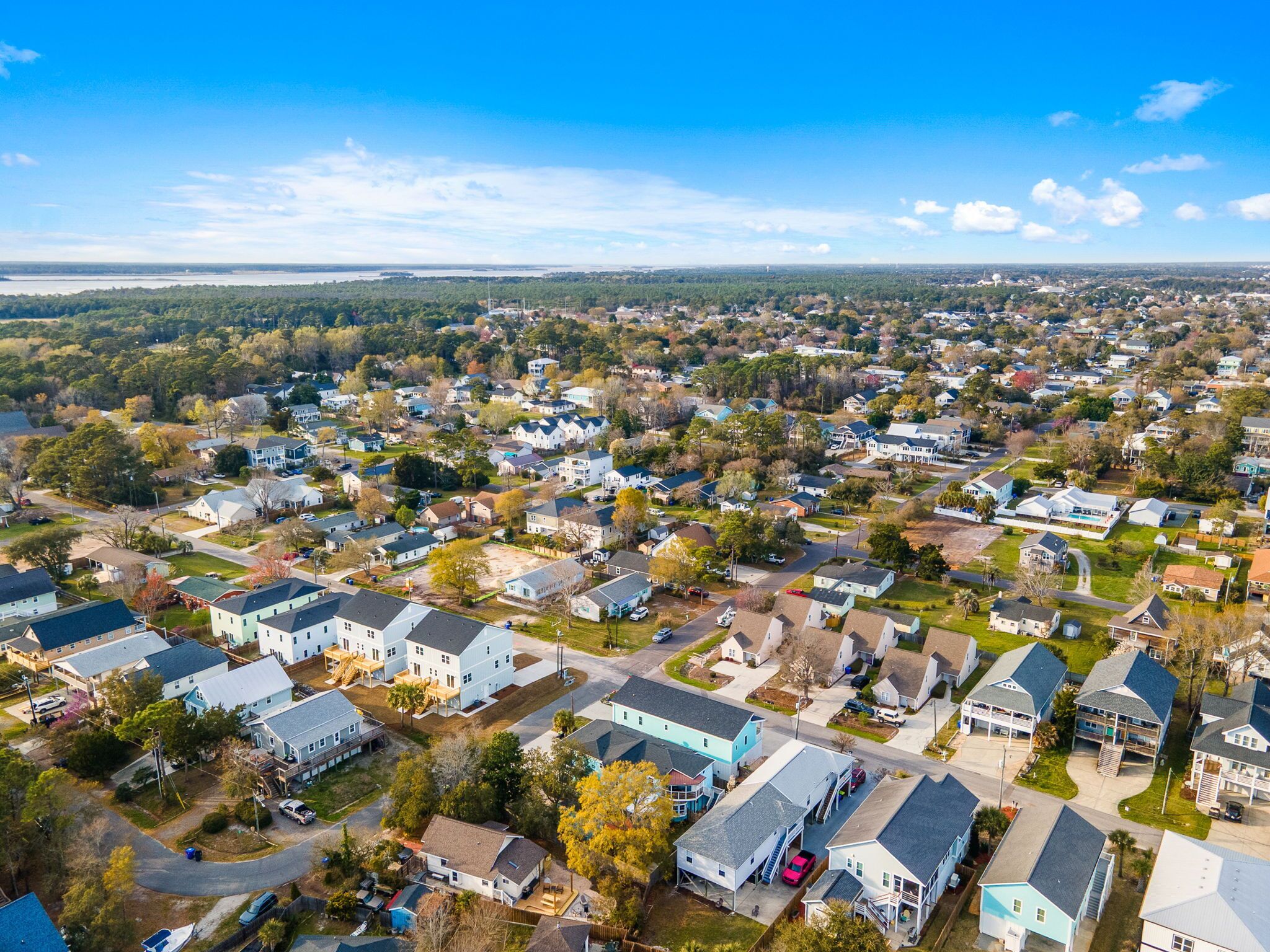 Vista aérea de una zona residencial con casas, caminos y vegetación.
