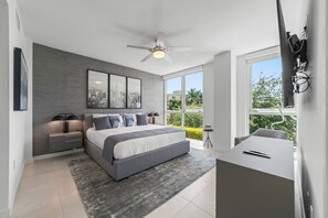 A modern bedroom with a large bed, a desk, and a cityscape view. - 2 Bed/3 Bath Beach Townhouse  I 1600sqft I 5 Star amenities I No Resort fee I (Fort Lauderdale)