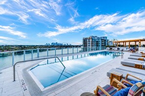 A rooftop pool with a city skyline view, lounge chairs, and a poolside bar. - 2BR+Den, 3 Bath,  Sleeps 6, 1,600sf, Beach Townhouse, 5-Star resort (Fort Lauderdale)