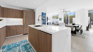 A modern kitchen with wooden cabinets, a white countertop, and a built-in dishwasher. - 2 Bed/3 Bath Beach Townhouse  I 1600sqft I 5 Star amenities I No Resort fee I (Fort Lauderdale)