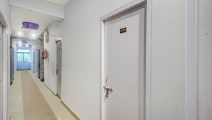 A hallway with white walls, a door labeled '208', and a ceiling light fixture. - Classic Hotel Four Square (Patna)
