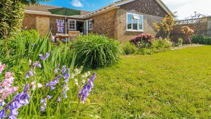 A brick house with a garden, a flag, and a lawn. - 2 Trelawny Way (Bembridge)