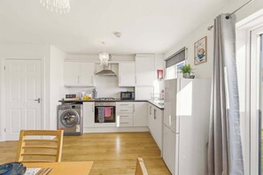 A compact kitchen with a washing machine, a microwave, and a sink.