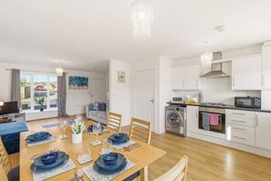 A modern kitchen with white cabinets, a microwave, and a gas stove.