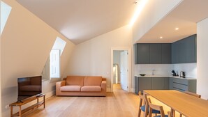 Eine moderne Wohnung mit einem Loftsichtwohnzimmer, einem Esstisch und einer Küche.