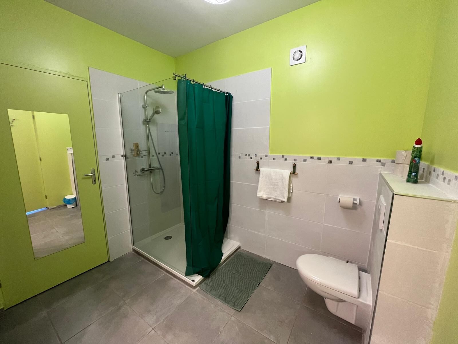 Un baño con cabina de ducha de vidrio, inodoro y lavamanos.