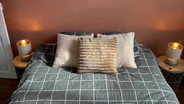 A bed with a checkered bedspread, two pillows, and two bedside lamps. - Intimate duplex apartment in village center (Bois-le-Roi)