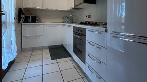 Una cocina moderna con armarios blancos, estufa, horno y refrigerador.
