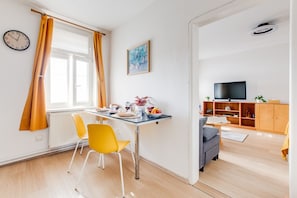 Un salon moderne comprenant un coin repas, un téléviseur et une horloge murale.