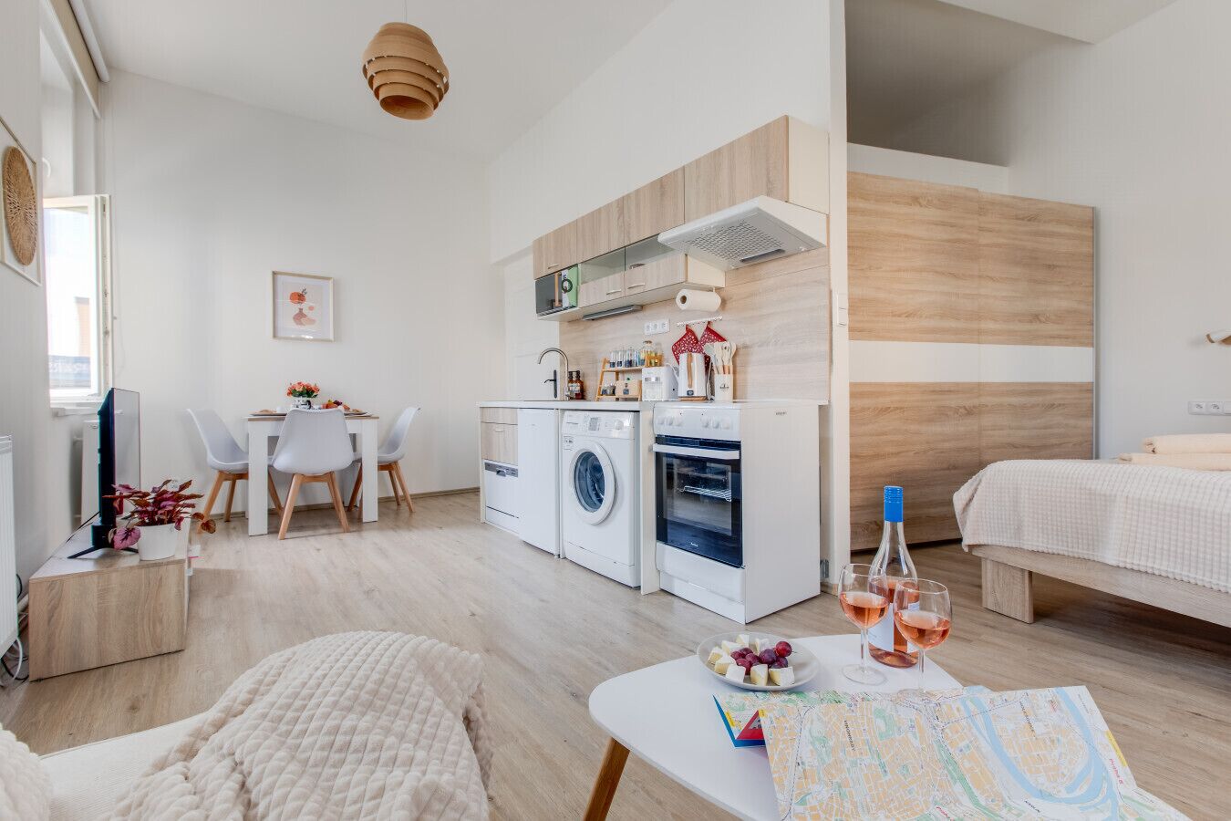 A modern apartment with a kitchen, dining area, and a bedroom.