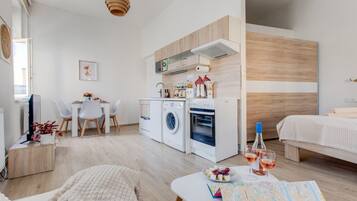 A modern apartment with a kitchen, dining area, and a bedroom.