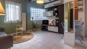 A living room with a TV, sofa, and a small table with plants. - Green Botanical House with Free Parking (San Giorgio di Piano)