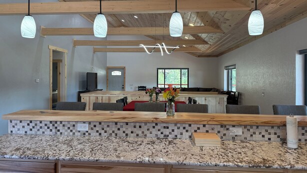 Una cucina moderna con travi in legno, un piano di lavoro in granito e un'isola centrale con posti a sedere.