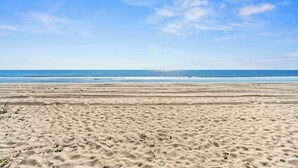 A wide sandy beach with gentle waves in the background. - Mini Golf Heated Pool Ocean Front Family Fun (Holden Beach)