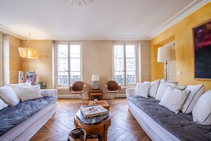 A living room with two sofas, a coffee table, and a lamp. - Saint Germain Artiste (Paris)