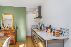 A kitchen with a wooden cabinet, a marble countertop, and a large mirror. - Le Boisé - Gites Bo - Studio Apartment, Sleeps 4 (Baubigny)