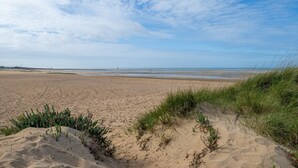 A sandy beach with dunes and sparse vegetation. - Les Essarts Marine - Au bord de la plage (Courseulles-sur-Mer)
