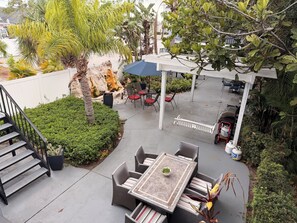 A patio with outdoor furniture, a table, and a covered seating area. - Tampa Oasis- In Unit Laundry (Tampa)