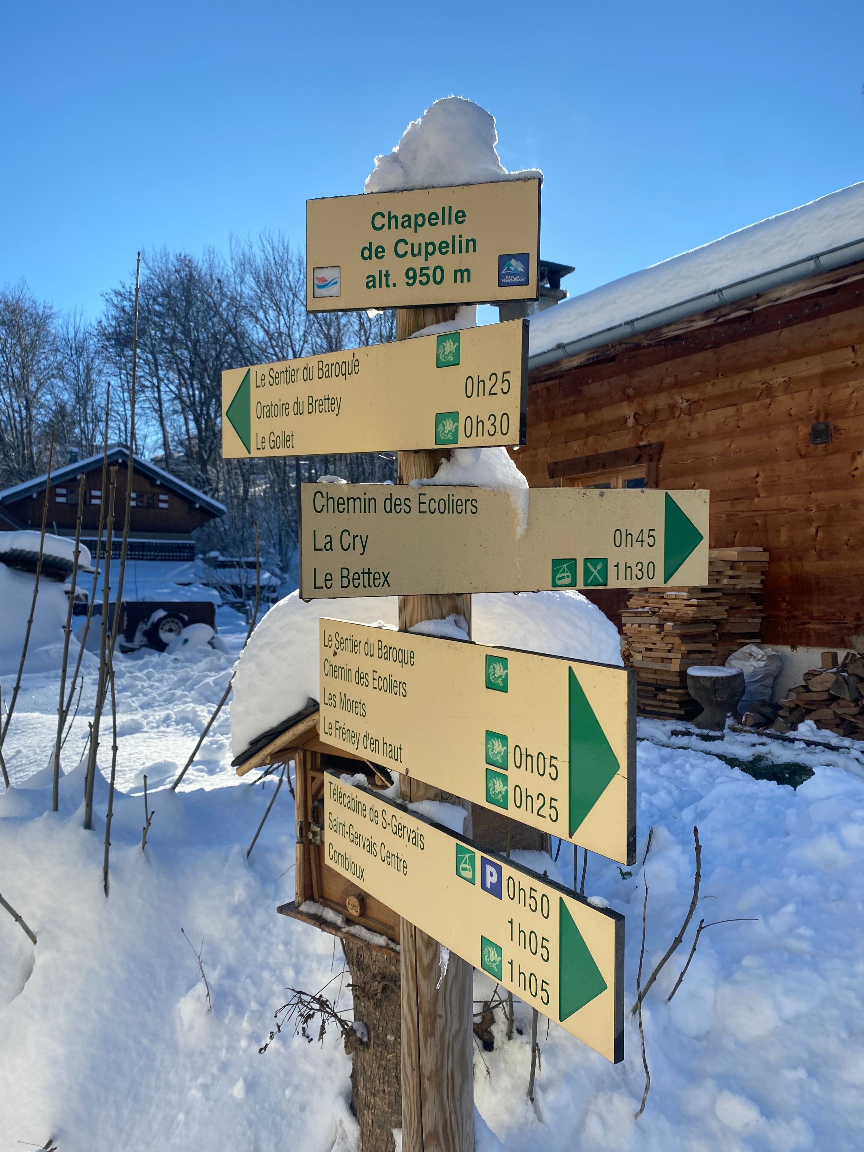 A directional signpost with multiple arrows pointing to various destinations, including Chapelle de Cupelin and La Cry.