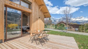 A wooden cabin with a deck, a dining area, and a mountain view. - Le Chalet Morets - Avec vue sur la montagne (Saint-Gervais-les-Bains)