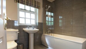 A bathroom with a toilet, sink, and bathtub. - Spacious stone cottage set in beautiful woodland with lovely views over a lake. (Darwin Lake, near Matlock)