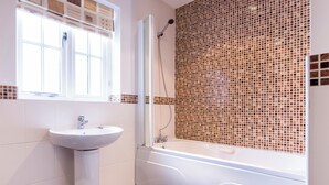 Un bagno con un lavandino bianco, una vasca e una doccia.