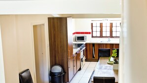 A compact kitchen with a microwave, stove, and wooden cabinets. - Attractive barn conversion set in three acres of shared grounds. (Carsington, near Ashbourne)