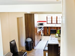A compact kitchen with a microwave, stove, and wooden cabinets. - Attractive barn conversion set in three acres of shared grounds. (Carsington, near Ashbourne)