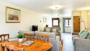 A living room with a dining table, sofas, and a TV. - 3 bedroom accommodation in Carsington, near Ashbourne (Carsington, near Ashbourne)