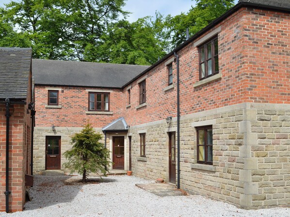 A brick building with a gravel courtyard, a small tree, and a door labeled 'FARWELL.' - 2 bedroom accommodation in Carsington, near Ashbourne (Carsington, near Ashbourne)