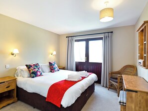 A hotel room with a bed, nightstands, a desk, a chair, a window with curtains, and a hanging light fixture. - Fine walking country is virtually on the doorstep. (Carsington, near Ashbourne)