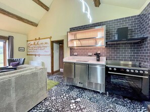 A modern kitchen with a stainless steel range hood, a built-in oven, and a tiled backsplash.