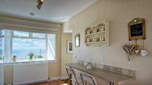 A kitchen with a view of the sea, a bar area, and decorative items on the wall.