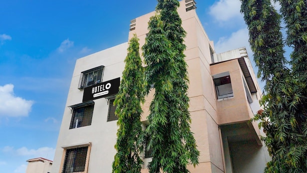 A modern hotel building with a sign reading 'HOTEL' and a company name. - Hotel O Laxman Nagar Baner (Pune)