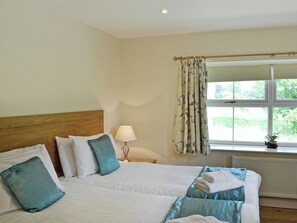 A double bed with a wooden headboard, two pillows, a bedside lamp, and a window with curtains. - 3 bedroom accommodation in Arden, Alexandria (Arden, Alexandria)