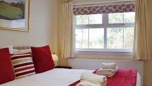 Une chambre d’hôtel avec un lit, des oreillers, une fenêtre et un radiateur.