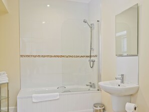 Ein Badezimmer mit Badewanne, Dusche, Waschbecken und Spiegel.