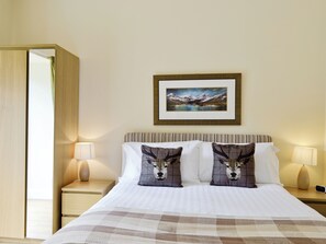 A hotel room with a bed, two bedside lamps, a framed picture on the wall, and a wooden door. - 1 bedroom accommodation in Arden, Alexandria (Arden, Alexandria)