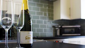 En flaska årgångscava och två tomma glas på en köksbänk.