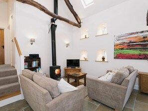 A cozy living room with a fireplace, comfortable seating, a television, and a painting on the wall. - 2 bedroom accommodation in Branthwaite, near Caldbeck (Branthwaite, near Caldbeck)